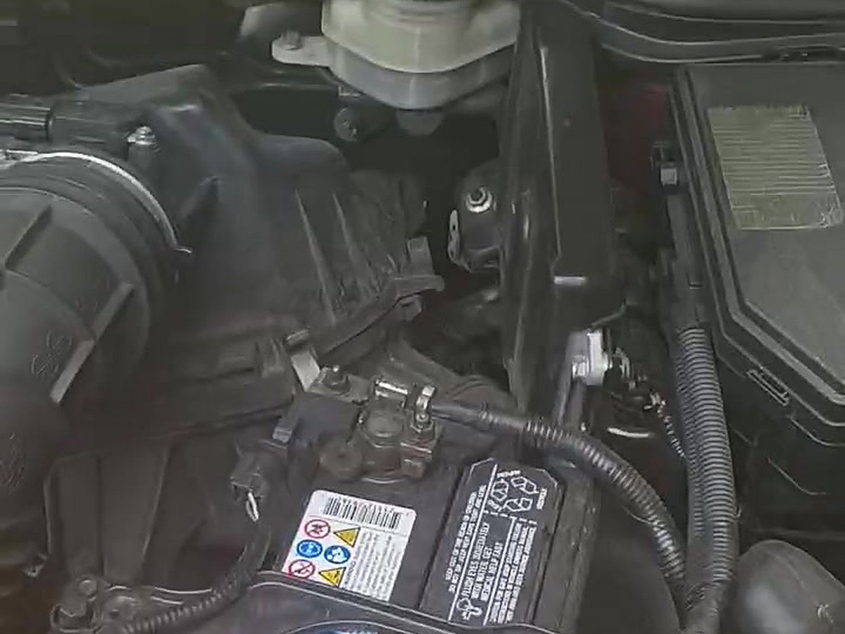 Engine bay of a car with the hood up, showing the airbox beside the battery